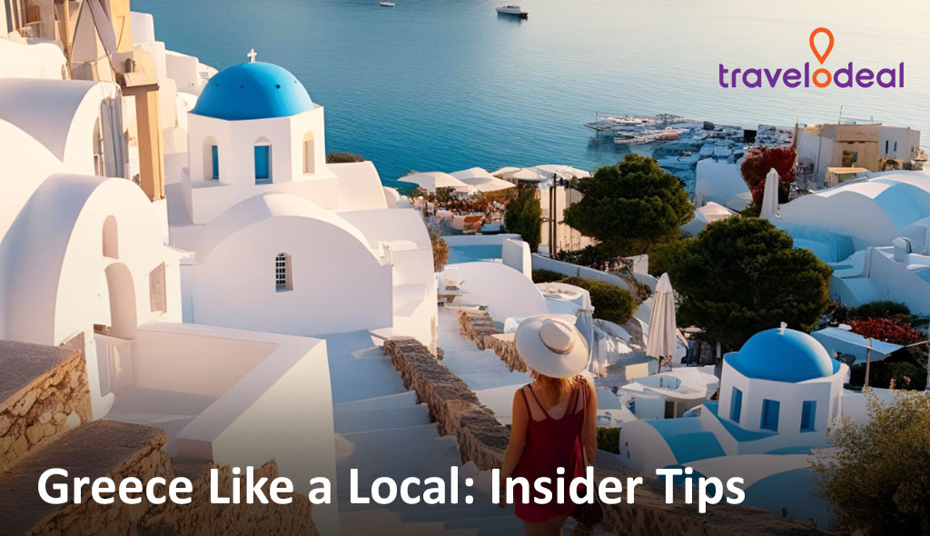 A woman in a sun hat walks down a scenic hillside in Greece, surrounded by white buildings and blue domes overlooking the sea.