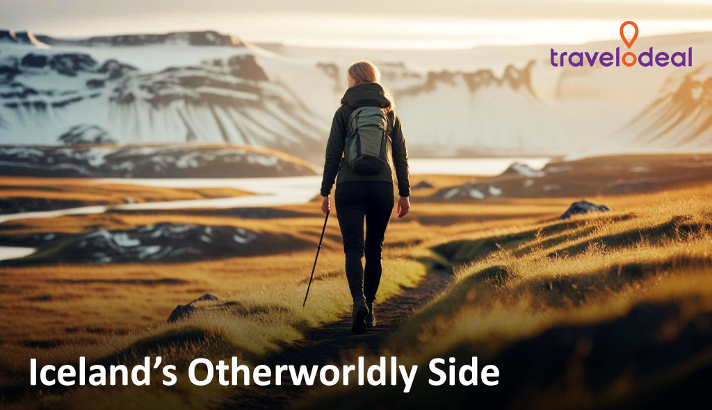 Person with backpack hiking through a rural Icelandic landscape with snow-capped mountains in the background.
